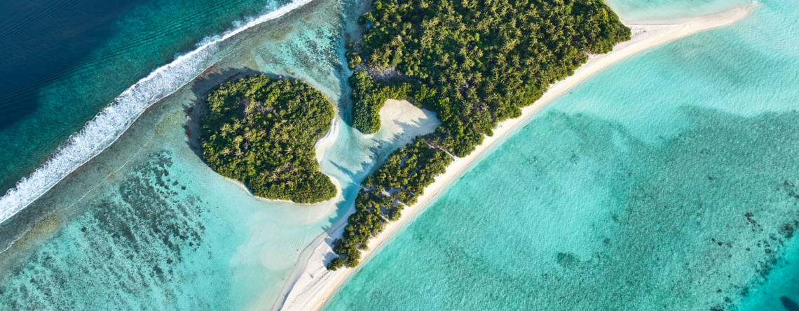 Aerial view of a tropical island and coral reef in Dhaalu Atoll, Maldives