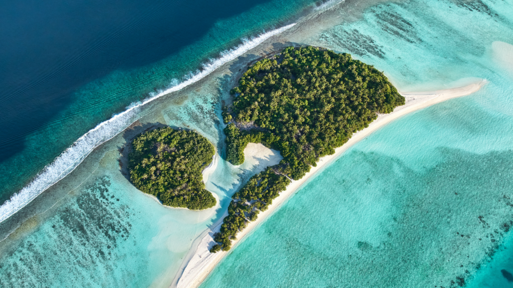 Aerial view of a tropical island and coral reef in Dhaalu Atoll, Maldives