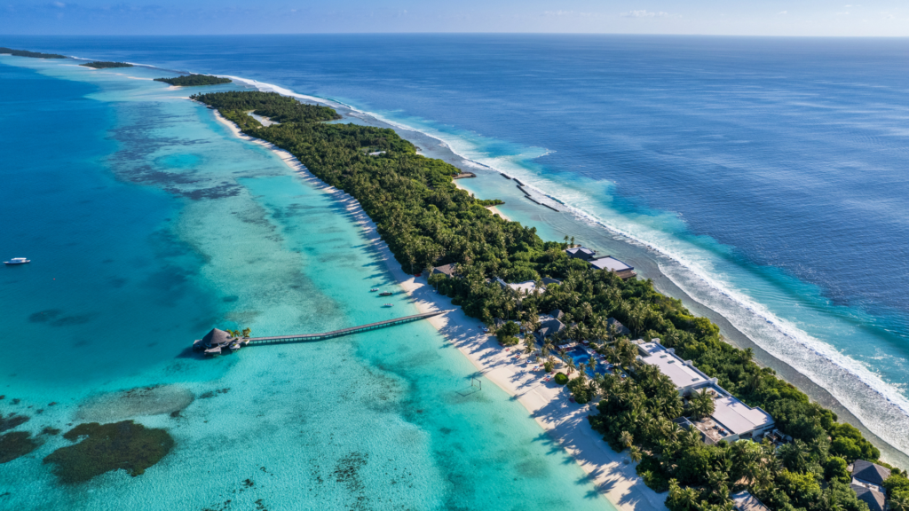 Aerial view of Kandima Maldives stretching along the reef in Dhaalu Atoll