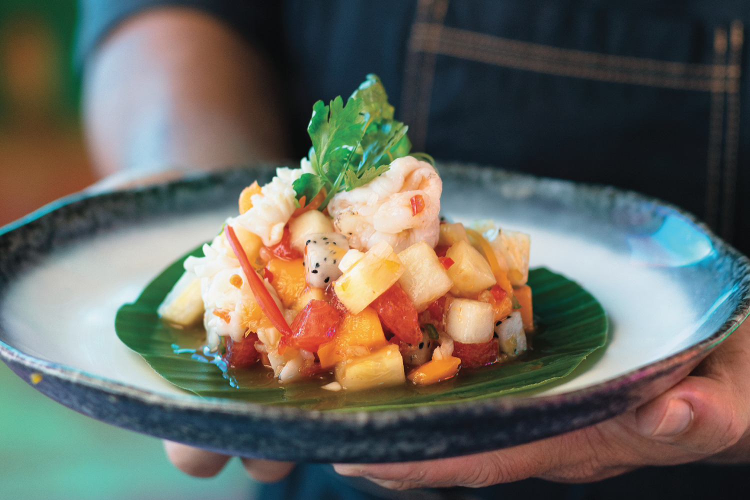 Chef presenting a colourful island-inspired dish at Kandima Maldives in Dhaalu Atoll.